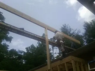 Carpenter setting a ridge beam over a new addition frame — Ice Dam Removal by Roofing Brothers in Dekalb