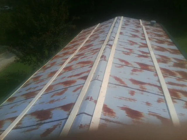 Rusted metal roof panels with new wood purlins before replacement — Storm Damage Roof Repair in Dekalb by Roofing Brothers