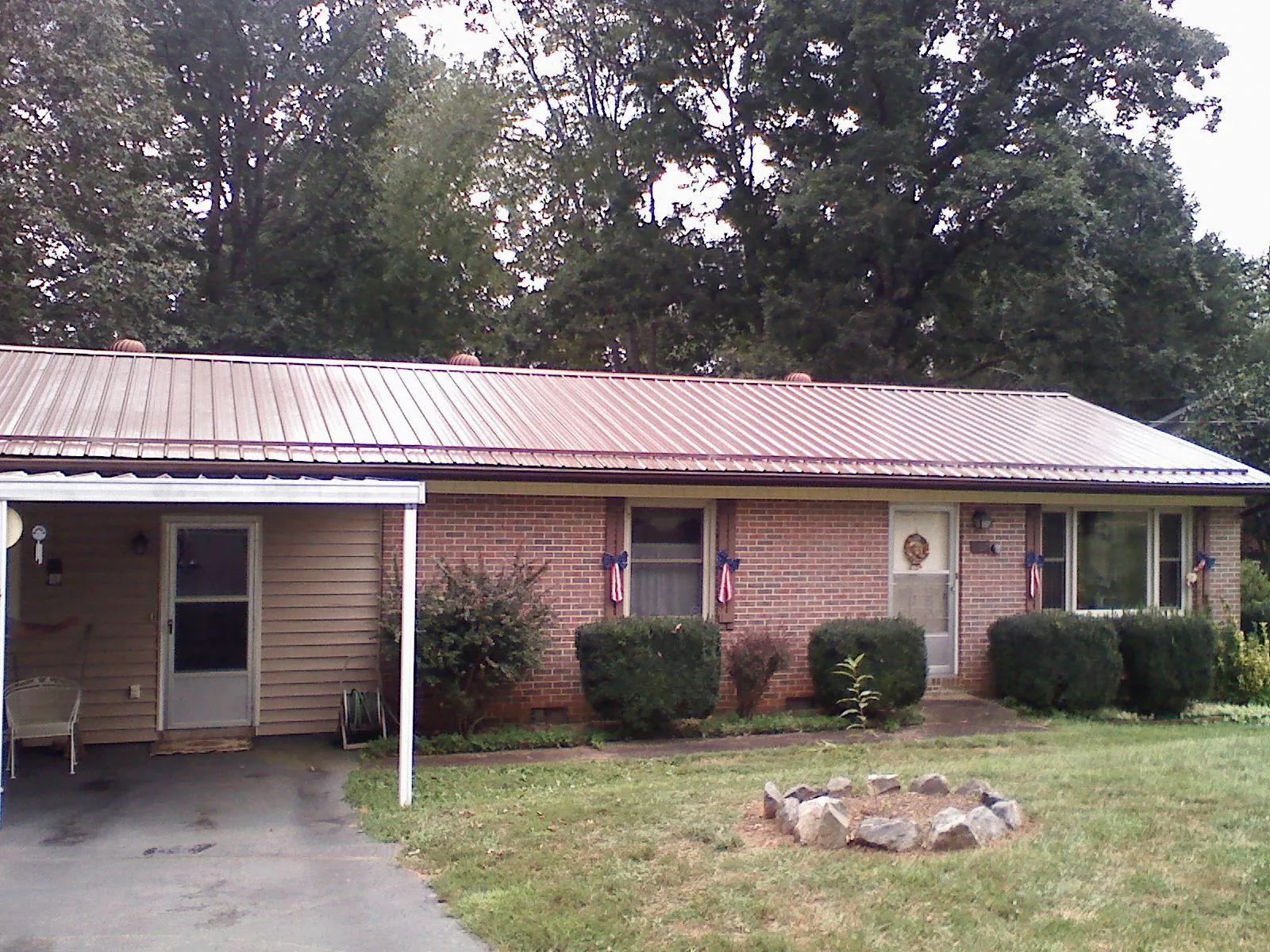 Bronze metal roof and carport on a brick ranch home — Roof Repair work by our crew in Dekalb